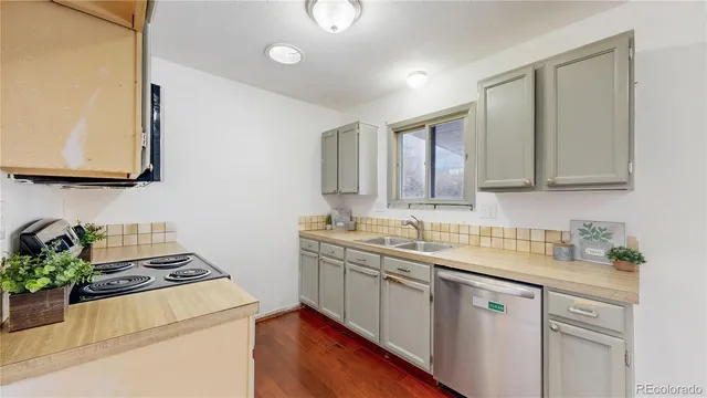 a kitchen with sink a stove and cabinets