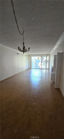 an empty room with chandelier fan and windows