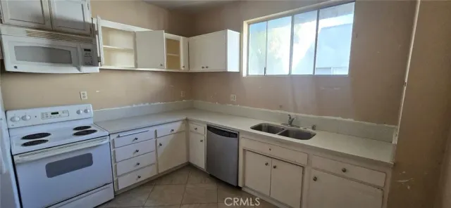 a kitchen with white cabinets and sink