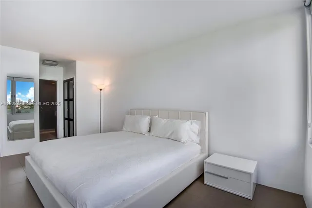 a large bed sitting in a bedroom and a table