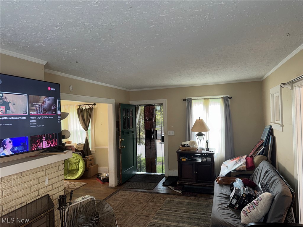 4406 Bayard Road Cleveland, OH 44121 - Photo 3 of 10 Living room with wood finished floors, a textured ceiling, and crown molding