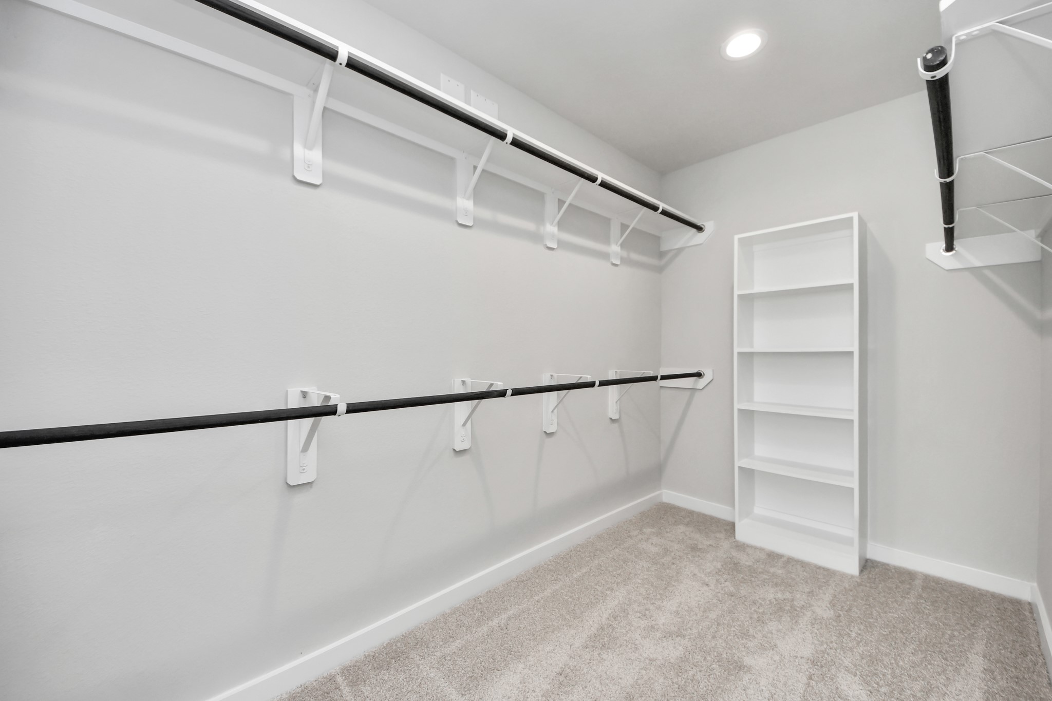 311 Ice Shr Trail Dayton, TX 77535 - Photo 28 of 35 Walk-in closet that epitomizes luxury and practicality. This generously sized space features built-in shelving, offering abundant room for impeccable organization. High ceilings and recessed lighting create a bright and welcoming ambiance. Sample photo of completed home with similar floor plan. Actual colors and selections may vary.