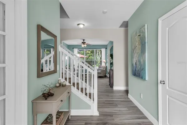 a dining room with furniture a chandelier and wooden floor