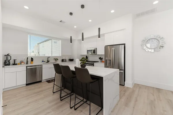 a large kitchen with a table and chairs
