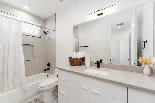a bathroom with a double vanity sink toilet and shower
