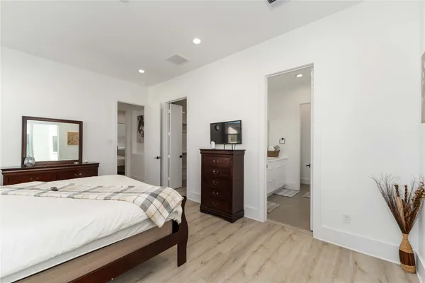 a bedroom with a bed and a refrigerator