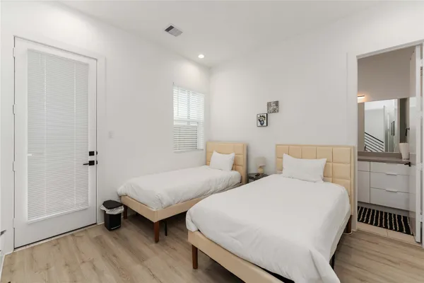 a bedroom with two beds and a lamp