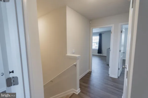 a view of a bedroom with wooden floor and window