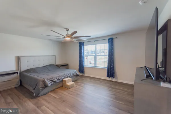 a view of an empty room with wooden floor and cabinet