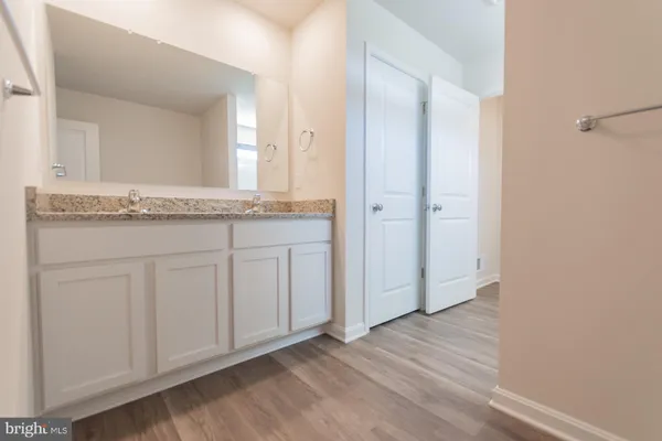 a view of an empty room with wooden floor and window