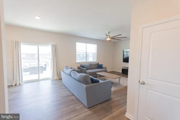 a kitchen with stainless steel appliances granite countertop a refrigerator a sink dishwasher a stove and white countertops with wooden floor