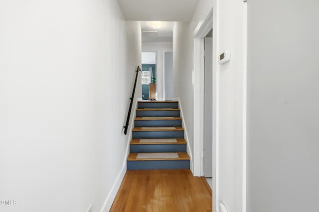 a view of a hallway with wooden floor and entryway