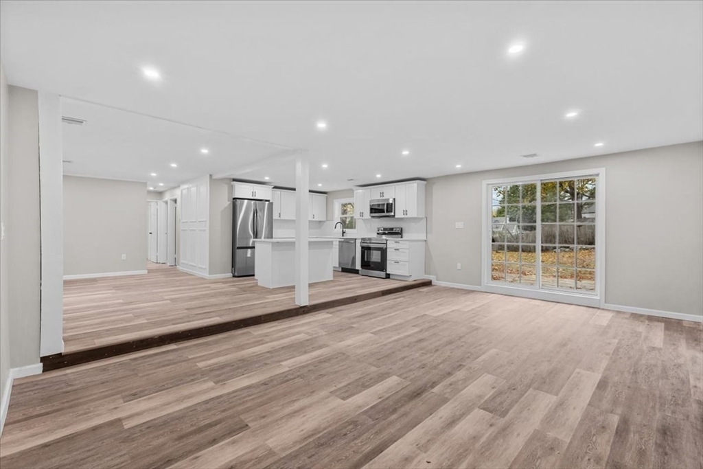 54 Mildred Road Brockton, MA 02302 - Photo 16 of 30 a view of empty room with wooden floor and kitchen