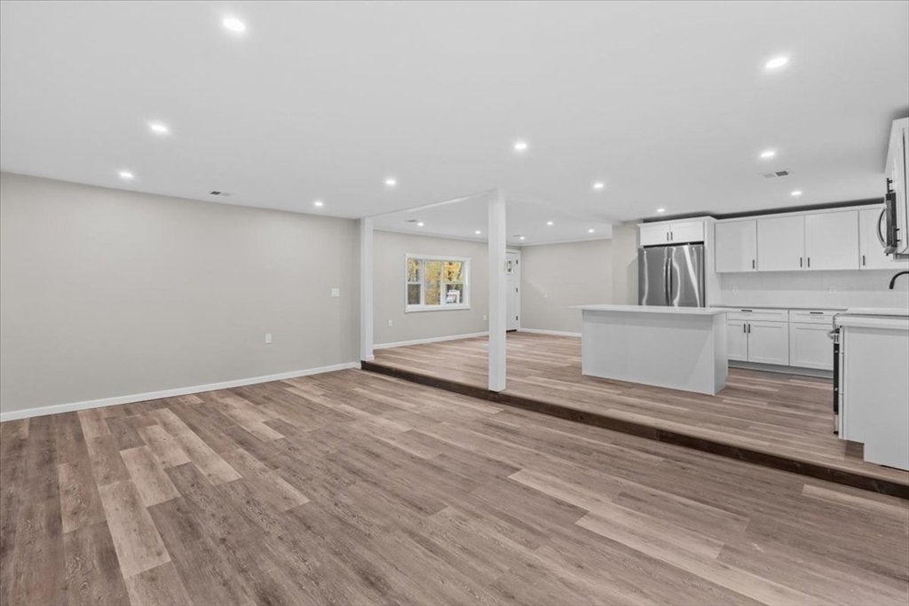 54 Mildred Road Brockton, MA 02302 - Photo 17 of 30 a view of a kitchen with kitchen island a sink wooden floor and stainless steel appliances
