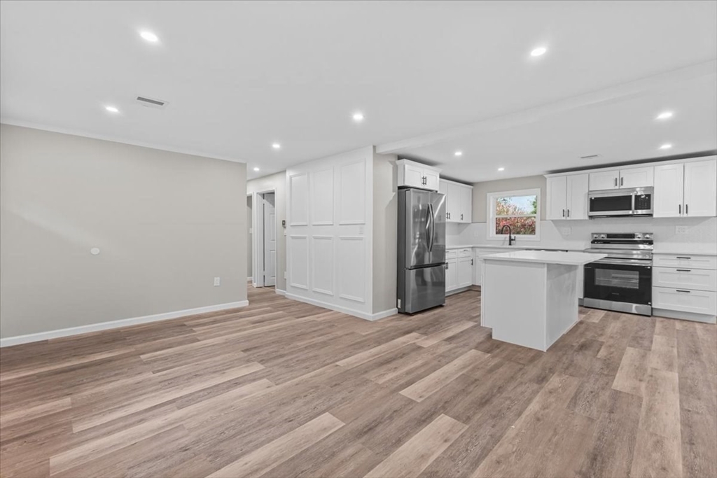 54 Mildred Road Brockton, MA 02302 - Photo 2 of 30 a large kitchen with stainless steel appliances kitchen island a large counter top and a stove top oven