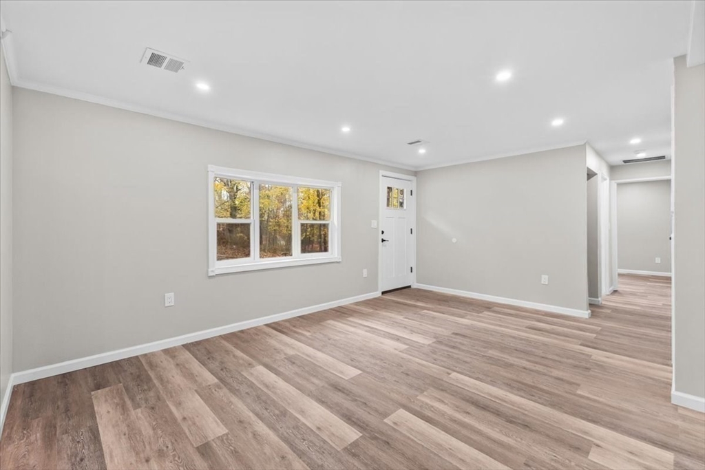 54 Mildred Road Brockton, MA 02302 - Photo 6 of 30 a view of an empty room with wooden floor and a window