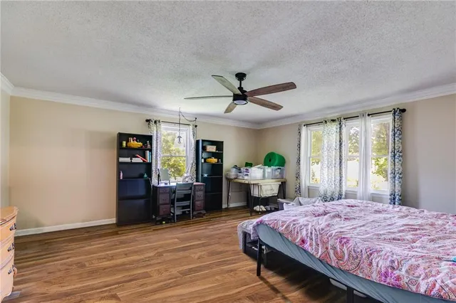 a spacious bedroom with a bed table and a window