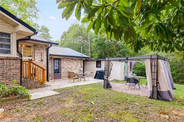 a view of a chair and table in backyard of the house