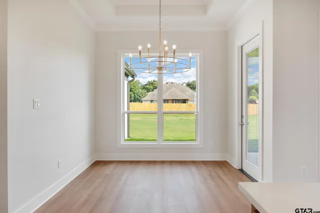a view of a room with window wooden floor and a chandelier