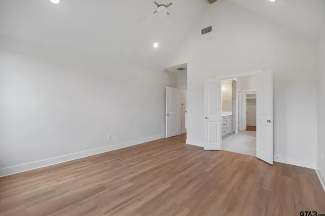a view of a big room with wooden floor and windows