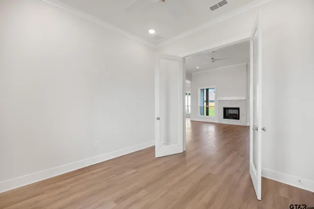 an empty room with wooden floor and fireplace