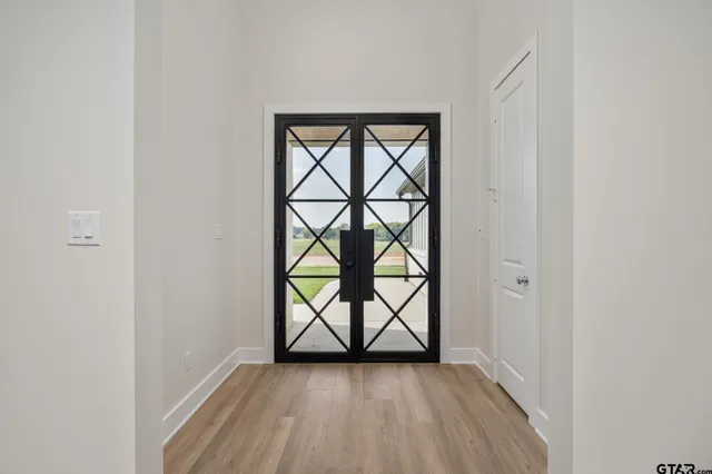 a view of a hallway with wooden floor and a window