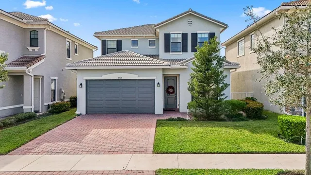 a front view of a house with a garden and plants