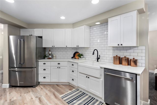 a kitchen with stainless steel appliances a stove microwave and refrigerator
