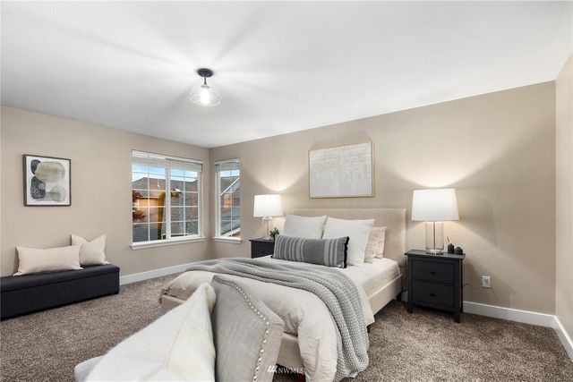 a spacious bedroom with a bed a table and painting