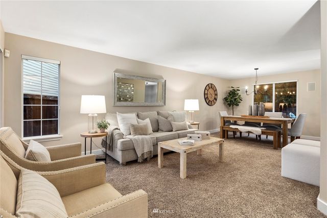 a living room with furniture a flat screen tv and a table