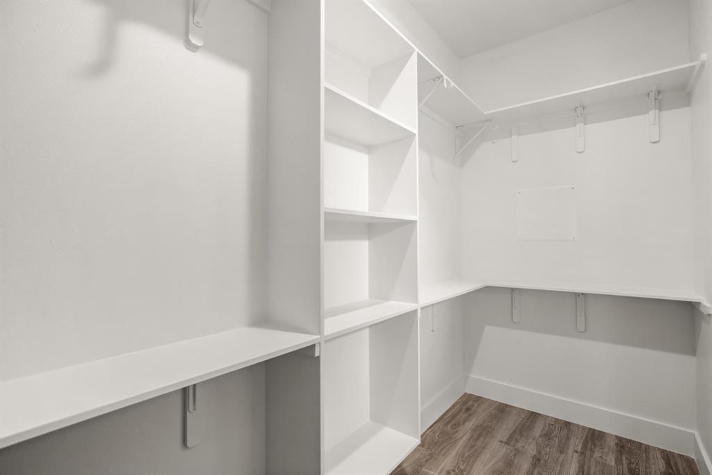1606 Harvey Street, Unit 2 Austin, TX 78702 - Photo 15 of 22 Custom closet system with built-in shelving, hanging rods, and wood-finish flooring