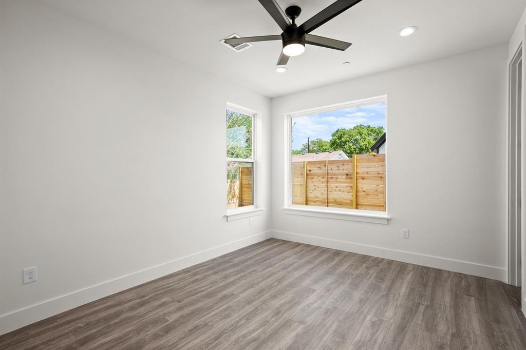 1606 Harvey Street, Unit 2 Austin, TX 78702 - Photo 16 of 22 Spacious room featuring wood-finish flooring, a contemporary ceiling fan with integrated lighting, recessed lighting fixtures, and large windows