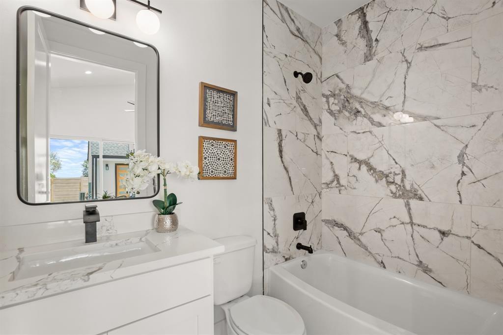 1606 Harvey Street, Unit 2 Austin, TX 78702 - Photo 17 of 22 Modern bathroom featuring a white vanity with integrated sink, matte black faucet, and a large rectangular mirror