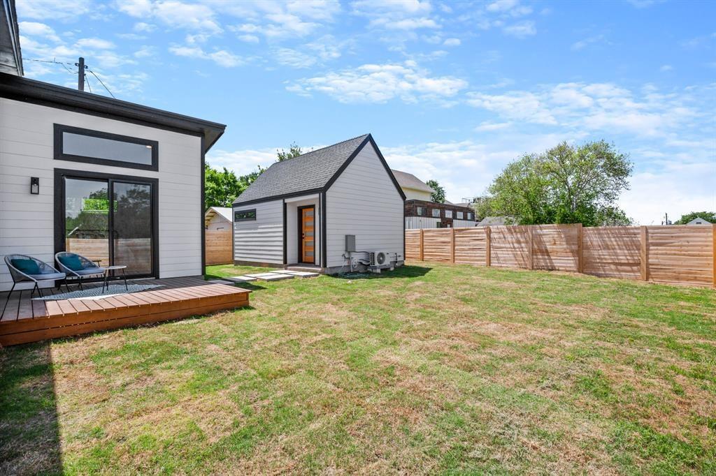 1606 Harvey Street, Unit 2 Austin, TX 78702 - Photo 19 of 22 Backyard featuring a wood deck patio with sliding glass door access, a detached accessory dwelling unit, and a horizontal wood fence