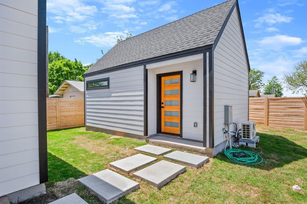 1606 Harvey Street, Unit 2 Austin, TX 78702 - Photo 21 of 22 Modern accessory dwelling unit with a contrasting black trim, natural wood-finish door with frosted glass panels, and a gabled roof