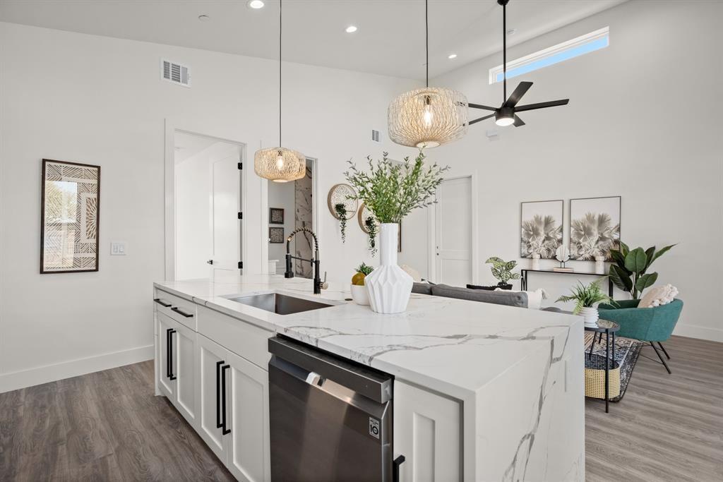 1606 Harvey Street, Unit 2 Austin, TX 78702 - Photo 7 of 22 Kitchen island featuring a waterfall-edge countertop, undermount sink, and stainless steel dishwasher