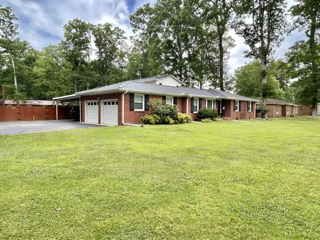 a view of a house with a yard and sitting area