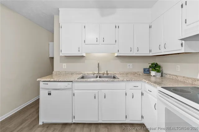 a kitchen with granite countertop white cabinets and a stove