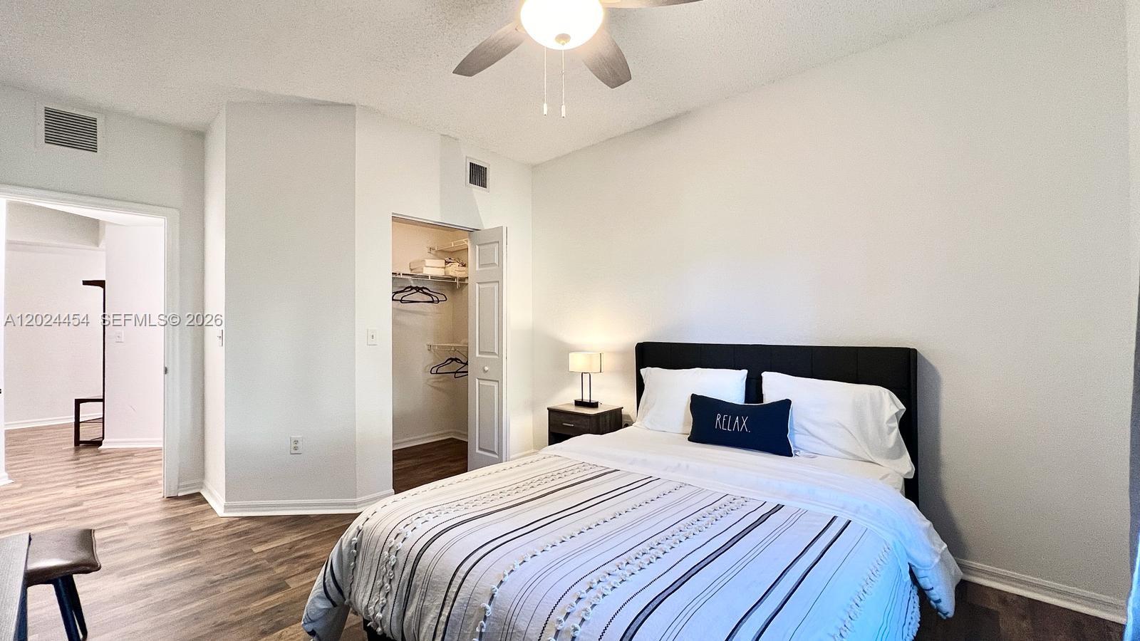 2727 Anzio Court, Unit 106 Palm Beach Gardens, FL 33410 - Photo 15 of 43 a bedroom with a bed and a chandelier