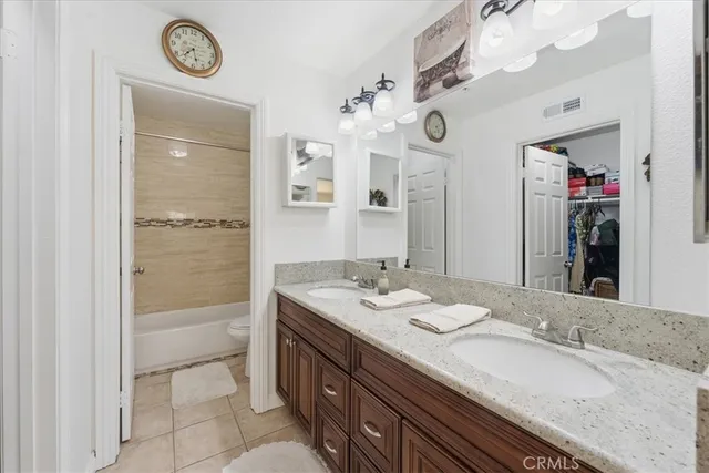 a bathroom with a granite countertop sink a mirror and a shower