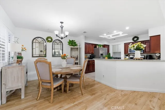 a view of a dining room with furniture a chandelier and wooden floor