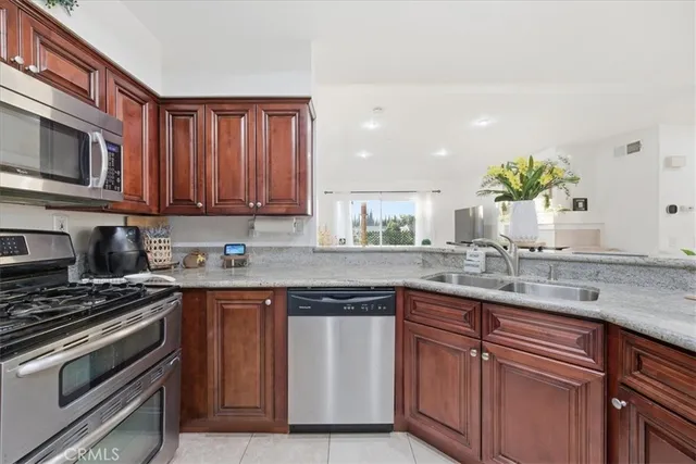a kitchen with stainless steel appliances granite countertop a sink and a stove
