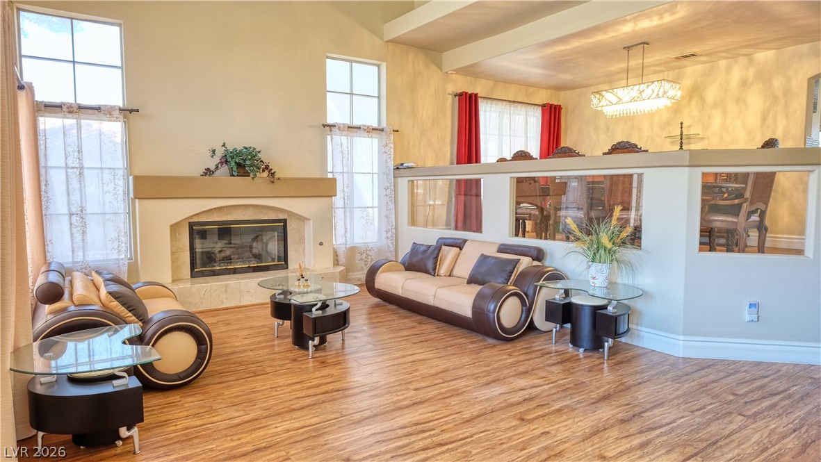 3704 North Campbell Road Las Vegas, NV 89129 - Photo 8 of 38 A striking fireplace anchors this generous living area, highlighted by a vaulted ceiling and rich wood flooring.