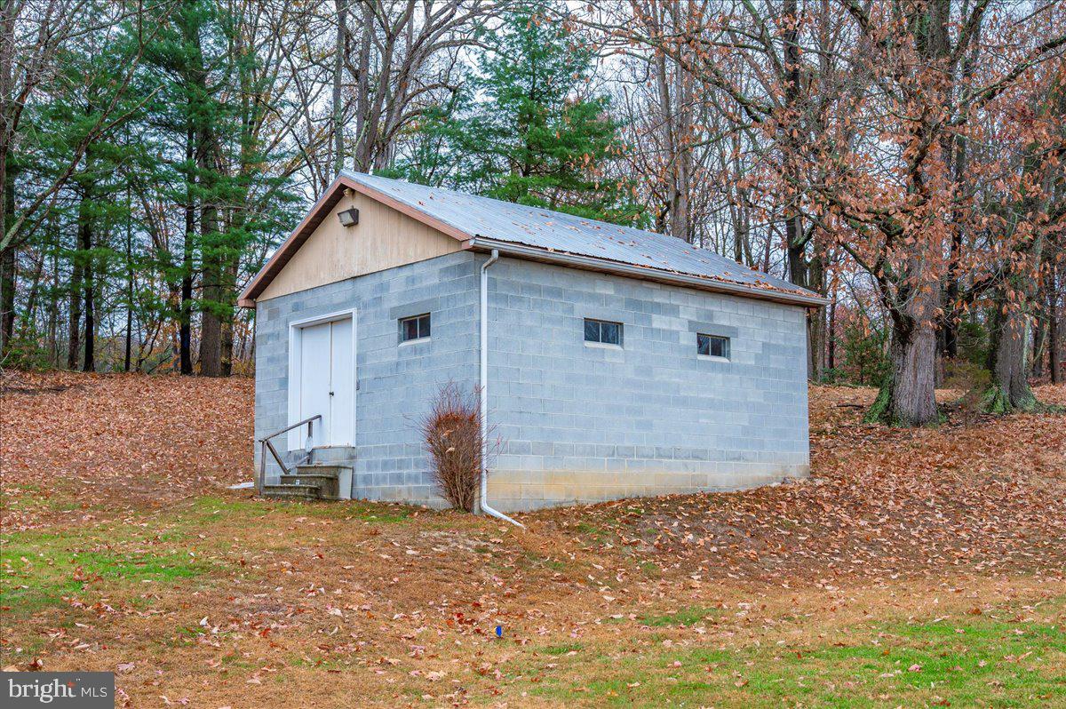 10622 National Pike Big Pool, MD 21711 - Photo 28 of 60 a view of a small white house with a large tree and wooden fence