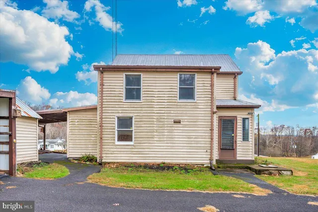 a view of a room with wooden floor next to a yard