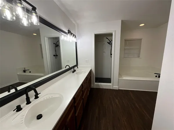 a bathroom with a double vanity sink and mirror with shower