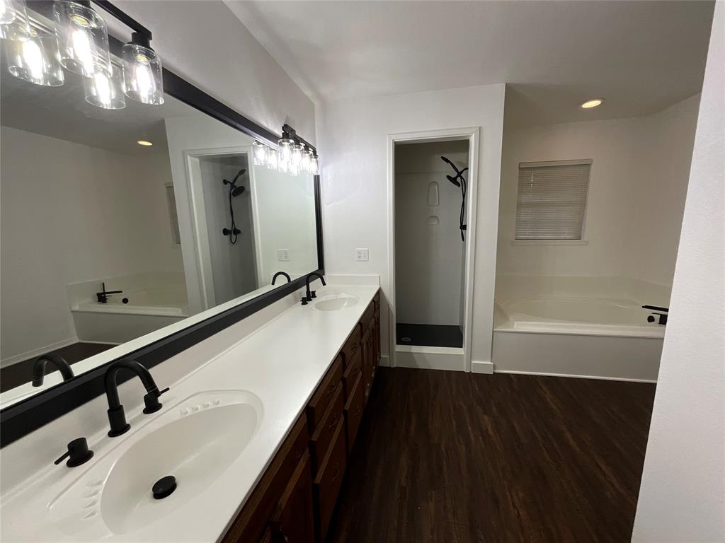 999 West Boynton Street Hamilton, TX 76531 - Photo 15 of 26 a bathroom with a double vanity sink and mirror with shower