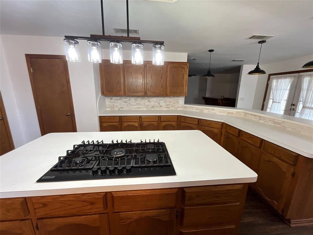 999 West Boynton Street Hamilton, TX 76531 - Photo 19 of 26 a kitchen with kitchen island a stove and a wooden floors
