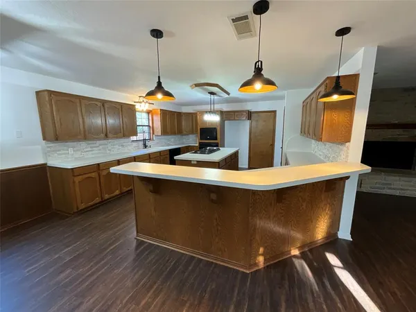a kitchen with stainless steel appliances granite countertop a stove a sink and a wooden floors
