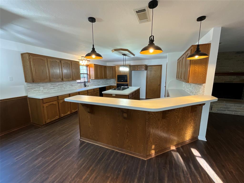 999 West Boynton Street Hamilton, TX 76531 - Photo 8 of 26 a kitchen with stainless steel appliances granite countertop a stove a sink and a wooden floors